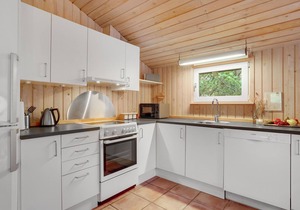 On a hilly natural plot surrounded by trees, lies this beautiful wooden vacation home. in Thisted