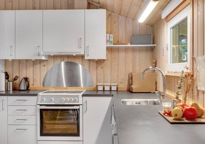 On a hilly natural plot surrounded by trees, lies this beautiful wooden vacation home. in Thisted