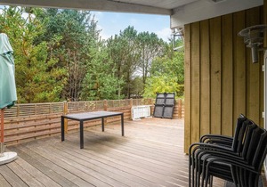 On a hilly natural plot surrounded by trees, lies this beautiful wooden vacation home. in Thisted