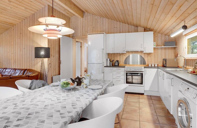 On a hilly natural plot surrounded by trees, lies this beautiful wooden vacation home. in Thisted